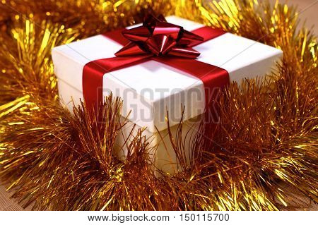 New Year gift on a golden tinsel background boly.