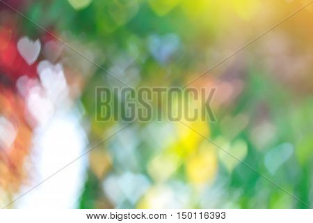colorful of abstract blurred bokeh with heart shape background and golden sunlight effect beautiful valentine texture background concept.
