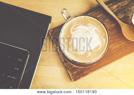 coffee cup on wood table and labtop