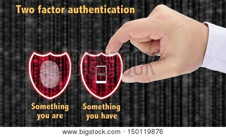Hand putting together two security shields revealing red datastreams showing the phrase something you are and have fingerprint and mobile two factor authentication concept
