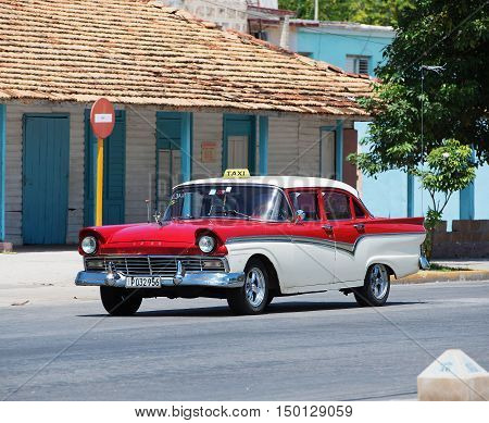 Varadero, Cuba - September 11, 2016:  Red and white American Classic Car Dirves in Varadero City, Cuba