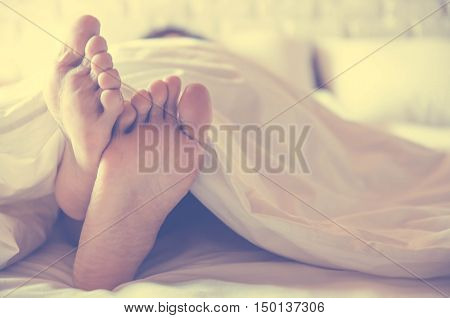 Close up feet of women sleeping women on bed