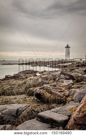 Portsmouth Harbor Lighthouse on a cloudy day in early Autumn in natural sepia tones, portrait