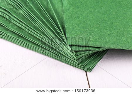 New green napkins on a white wooden dinner table сclose up