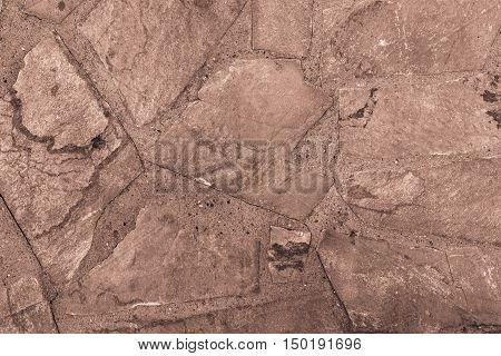 the abstract textured background or wallpaper of brown color from a shapeless stone tile