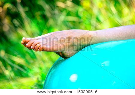 A toned leg well stetched out during a bent over exercise