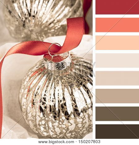 An antique glass Christmas tree bauble on red ribbon. In a colour palette with complimentary colour swatches.