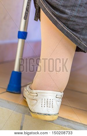 Age Woman With A Crutch Wearing Compression Stockings