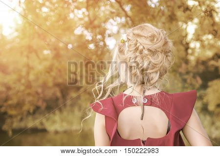 Back view of the young female with beautiful blond straight long hairs in motion