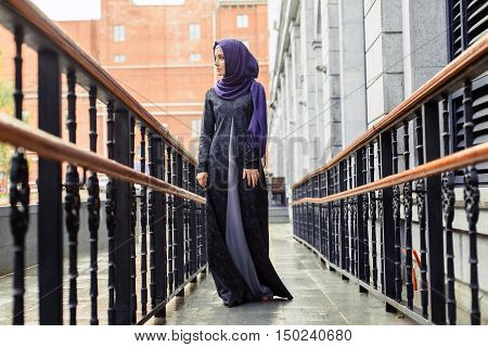 modern Muslim woman in beautiful Eastern dress standing on the background of the hotel Russia
