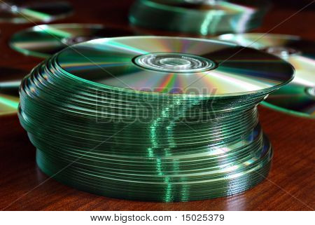 Stosy płyt CD lub DVD na powierzchni drewna.  Makro z bardzo płytkie dof.  Selektywnej ostrości z przodu 