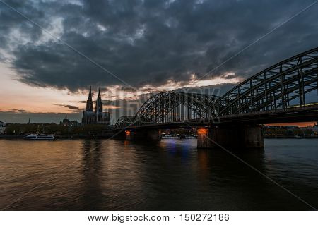 Sunset view of Cologne Cathedral and Hohenzollern Bridge, Germany. Travel photo of Germany.