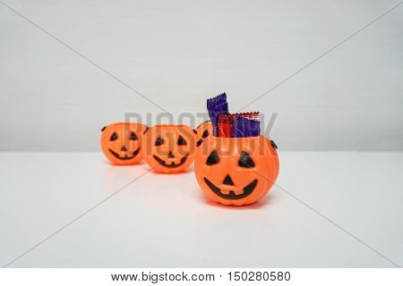 isolated Jack-O-Lantern pumpkin with colorful candies on table