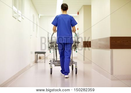 people, healthcare, reanimation and medicine concept - nurse carrying hospital gurney to emergency room