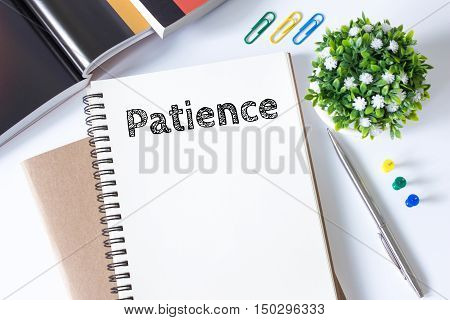 patience word message on white paper book and copy space on white desk / business concept / top view