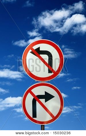 zwei entgegengesetzte Verkehrszeichen gegen blauen Himmel und Wolken