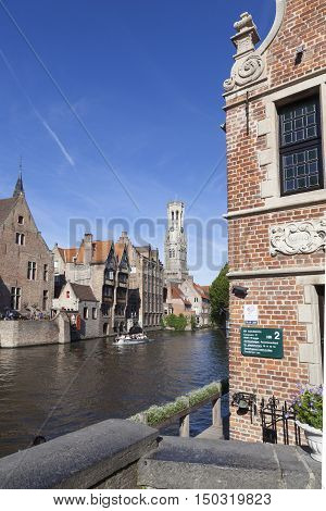 Maarssen, Netherlands, 30 september 2016: old houses and tourist boat in canal in centre of medieval Brugge in Belgium with blue sky in summer