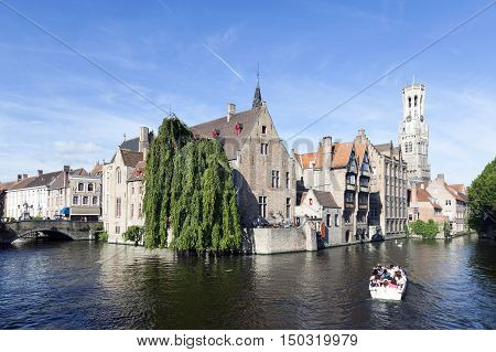 Maarssen, Netherlands, 30 september 2016: old houses and tourist boat in canal in centre of medieval Brugge in Belgium with blue sky in summer