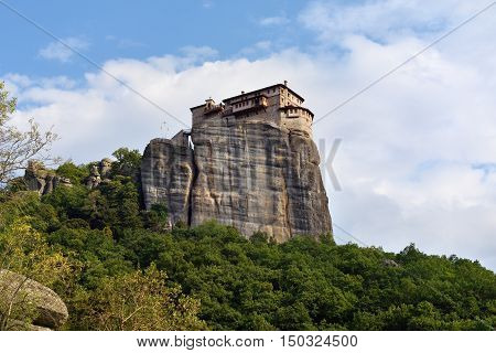 View from bottom on the Holy Monastery Roussanov at sunset time Meteora Greece
