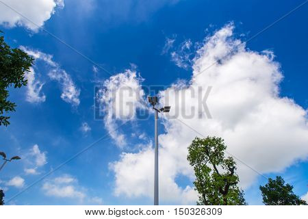 Illuminated street light lamp post against blue sky background