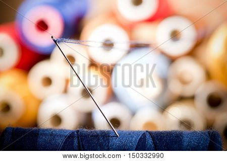 detail of a needle with thread in the workroomshallow depth of field