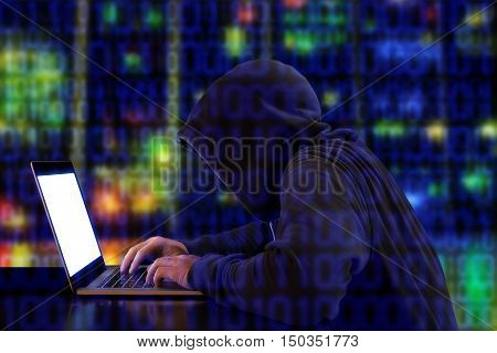 Hacker in a green hoody sitting in front of a notebook with colored server background and binary streams cybersecurity concept