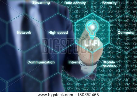 IT expert in a blue suit touches a Lifi symbol in a hexagon grid surrounded by topic related words like high speed or communication