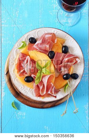 Parma ham with melon and glass of red wine