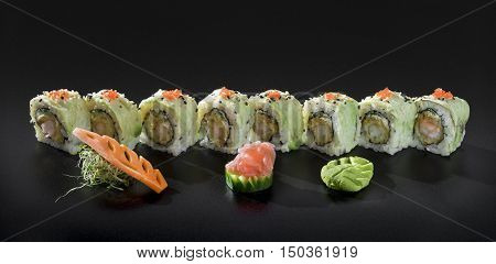 Japanese Sushi rolls. Uramaki maki sushi with fresh seaweed salad and wasabi