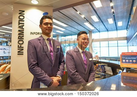 SINGAPORE - SEPTEMBER 12, 2016: portrait of a airport staff at information desk in Singapore Changi Airport. Changi Airport, is the primary civilian airport for Singapore.