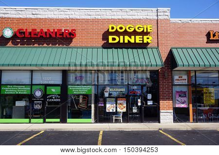 PLAINFIELD, ILLINOIS / UNITED STATES - SEPTEMBER 19, 2016: One may eat hot dogs and other fast foods at the Doggie Diner, and have one's clothes cleaned at the Perfect Fit Cleaners, in a Plainfield strip mall.