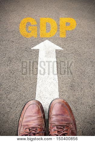Old brown leather shoes and Text for GDP. Concept on the road surface marking with arrow for any design