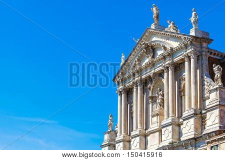 Church Scalzi. Santa Maria di Nazareth in Venice. Italy. Ancient Catholic cathedral with antique statues and columns over blue summer sky