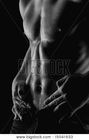 Sexy homme nu musclé avec des gouttes d'eau sur l'estomac