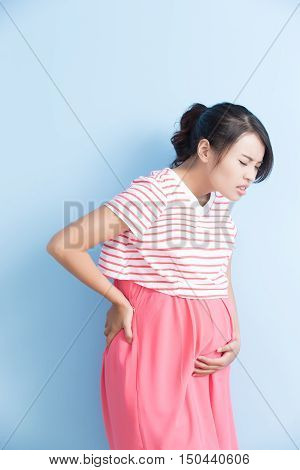 pregnant woman have pain isolated on bluebackground asian
