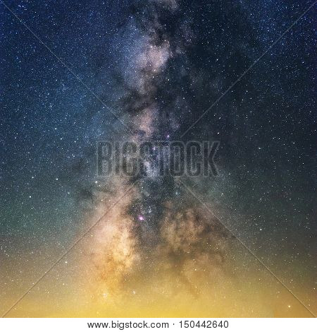 Beautiful night sky with vivid milky way. Yellow light polution at horizon. Astronomy dream dark sky.