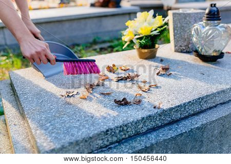 A Woman Cleans The Grave