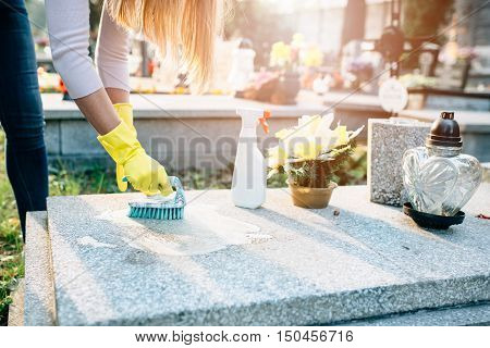 A Woman Cleans The Grave.