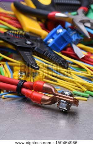 Electrical tools and cables used in electrical installations on grey metal background