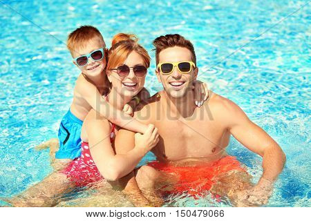 Happy family in swimming pool at water park