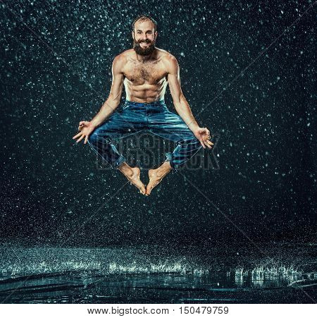 The male break dancer in water on dark background.