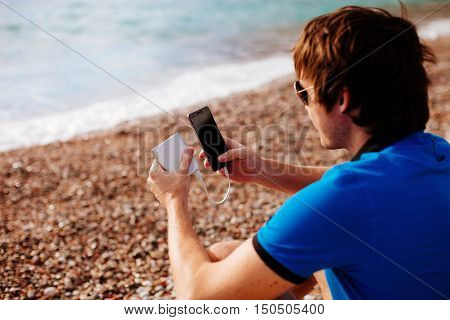 Man Charging Smartphone With Powerbank