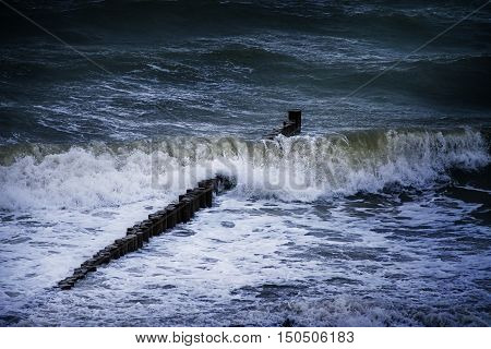 groynes a row of wooden piles as a breakwater in front of the beach in the stormy sea waves typical at the baltic sea in mecklenburg northern Germany