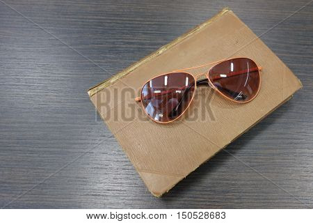 Brown book and sunglasses in orange frame