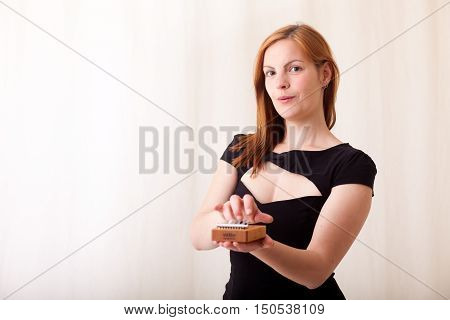 Woman with red hair and a Kalimba