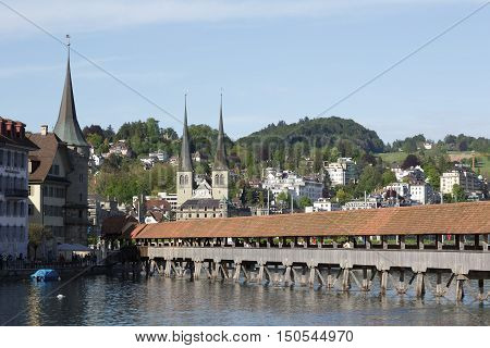 LUCERNE SWITZERLAND - MAY 09 2016: Chapel Bridge on the right bank of the river Reus ends up among the historic architecture that is attraction for many tourists arriving to town