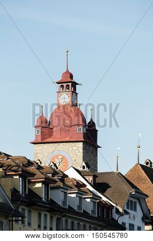 LUCERNE SWITZERLAND - MAY 04 2016: Clock tower that is a part of Town Hall towering over other city buildings. The Clock Tower with its huge clock is height over 40 meters.