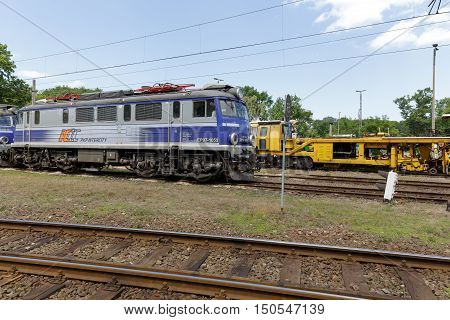 KOLOBRZEG POLAND - JUNE 23 2016: EP07 electric locomotive is painted in white blue colors of PKP Intercity it is at the side track of the train station in the city