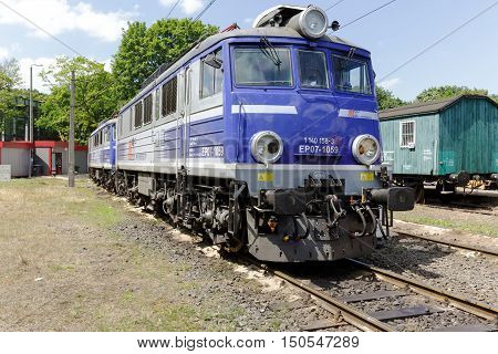 KOLOBRZEG POLAND - JUNE 23 2016: EP07 electric locomotive is painted in white blue colors of PKP Intercity it is parked at the side track of the train station in the city