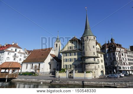 LUCERNE SWITZERLAND - MAY 05 2016: Haus zur Gilgen one of the oldest stone houses in the city and St. Peter Chapel both buildings are located on the right bank of river Reuss